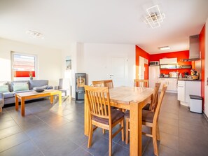 A modern apartment with a dining area, kitchen, and living room.