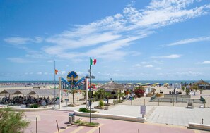 Une zone de plage avec un grand panneau, un drapeau et un espace de stationnement pour vélos.
