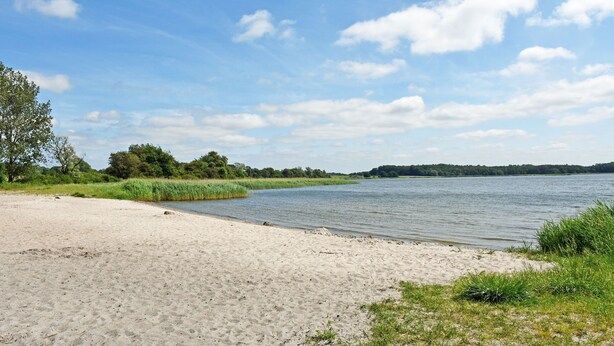 A sandy beach with a calm lake, surrounded by greenery and trees. - Vacation apartment Victoria with terrace and garden view - Holiday apartment Victoria with (Gustow)