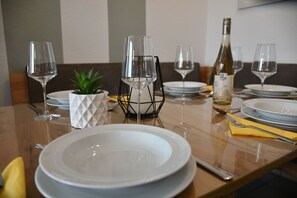 A dining table set with plates, wine glasses, and cutlery.