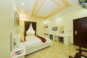 A hotel room with a bed, desk, TV, and wardrobe. - Mai Anh Hotel (Lao Cai)