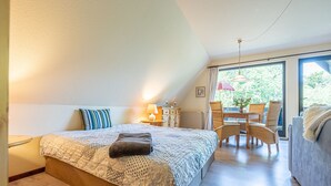 Une chambre à coucher comprenant un lit, un bureau et un coin repas avec des chaises.