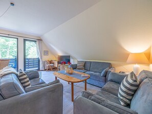 A modern living room with a sofa set, a wooden coffee table, and a lamp.