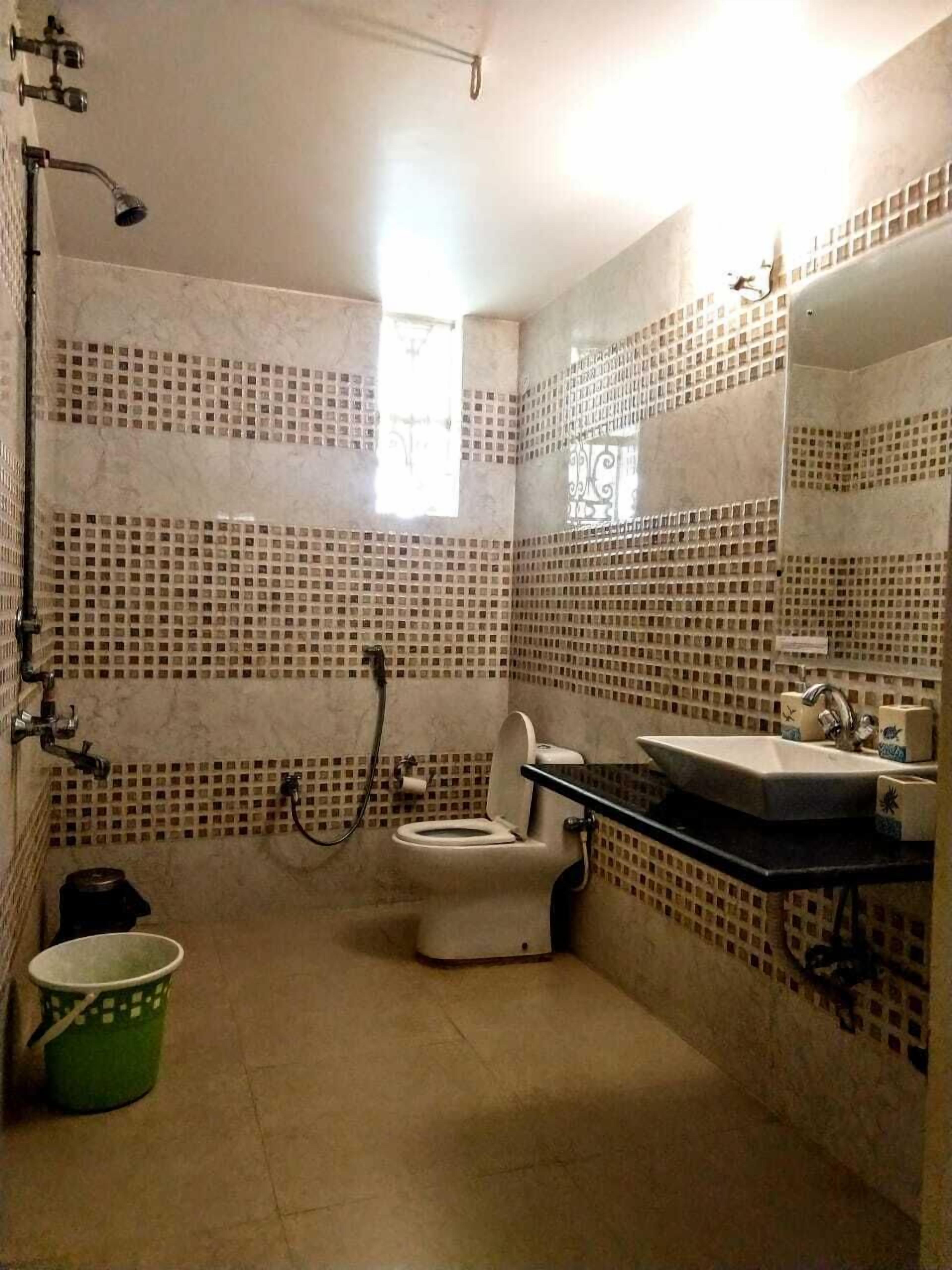 A bathroom with a toilet, sink, and shower.