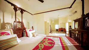 A traditional room with a bed, wooden furniture, and a ceiling fan.
