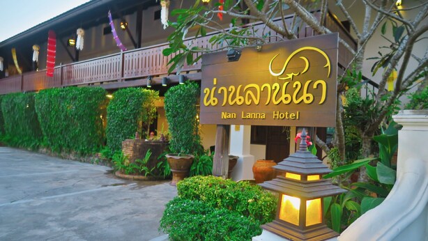 Exterior do Hotel Nan Lanka com uma placa, plantas em vasos e um lança-lumes tradicional.