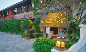 Exterior del hotel Nan Lanka, con un letrero, plantas en macetas y un farol tradicional.