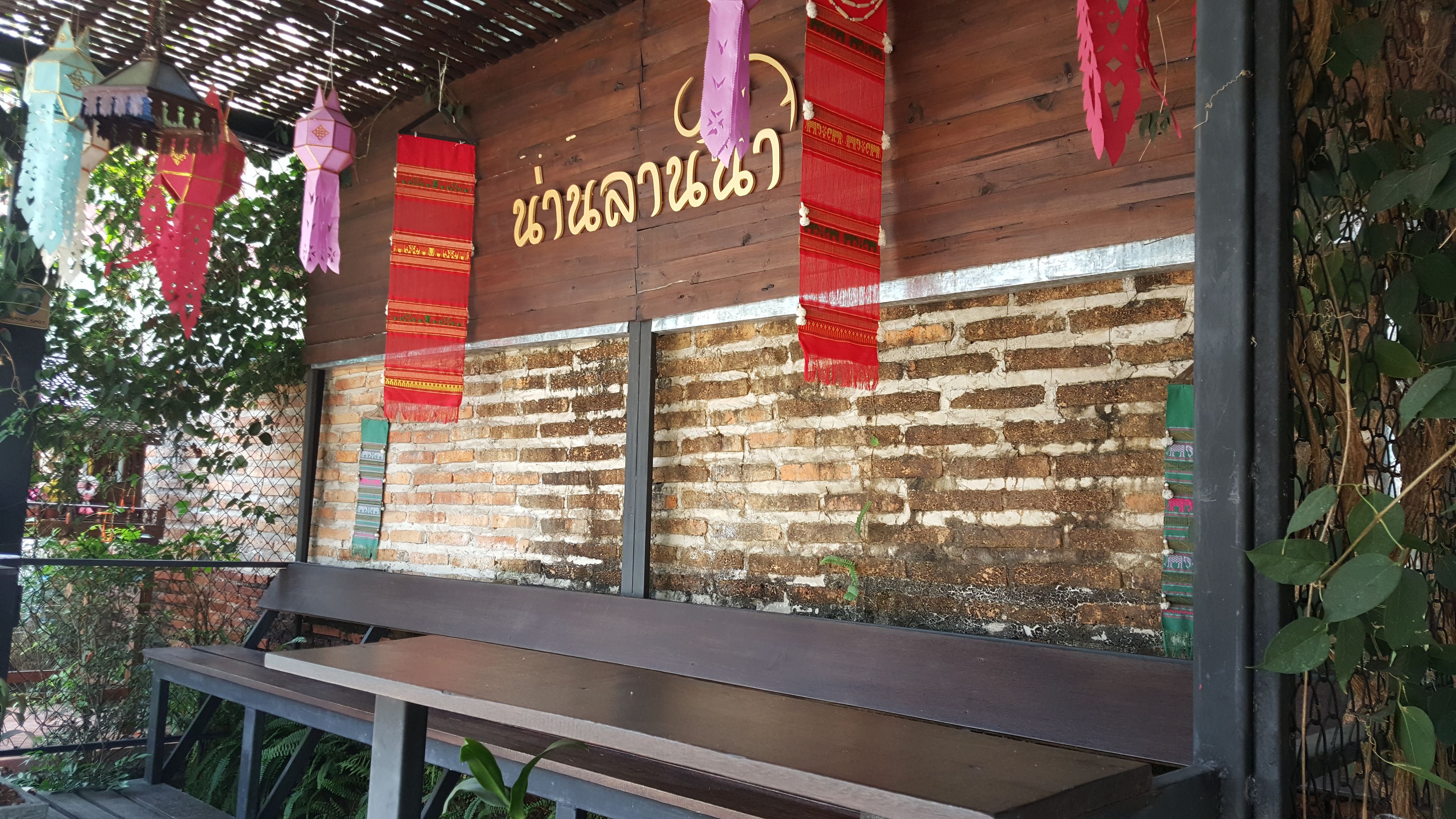 A wooden wall with a brick pattern and hanging decorations.