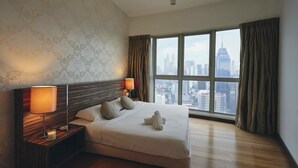 A hotel room with a large window, a neatly made bed, a nightstand with a lamp, and a view of a cityscape. - Regalia Residence @ KLCC View Sky Pool by MC (Kuala Lumpur)