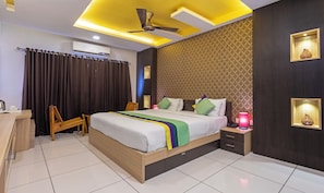 A modern hotel room with a bed, bedside table, lamp, and a ceiling fan. - Treebo Grand Canyon By D2V (Kochi)