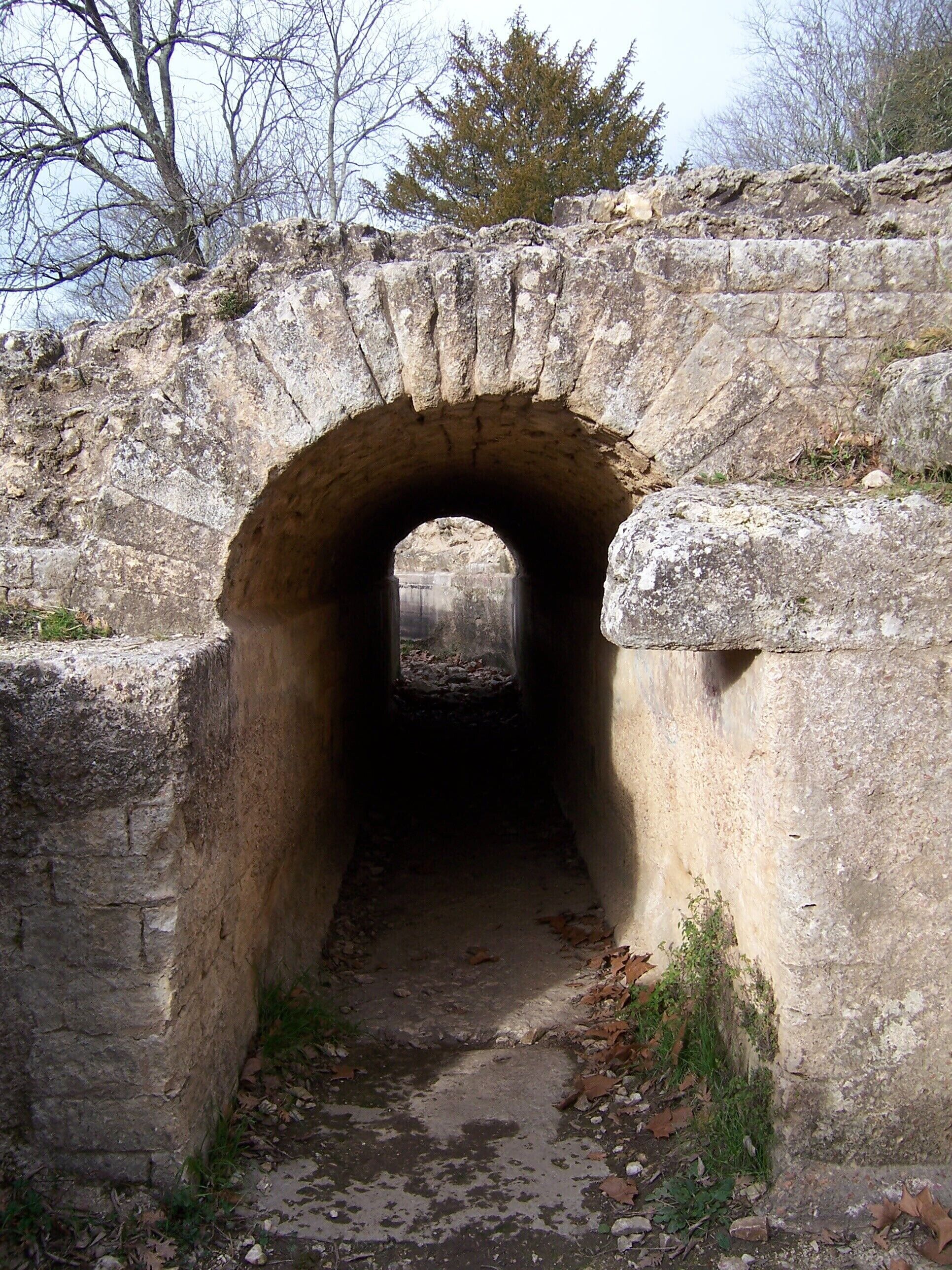 Un túnel de piedra con una superficie rugosa e irregular y un estrecho pasaje.