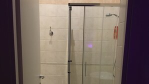 A bathroom with a glass-enclosed shower, a sink, and a toilet. - DuomoSuite (Naples)