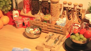 A kitchen counter with various food items, including jars of nuts, a bowl of grapes, and a container of yogurt. - DuomoSuite (Naples)