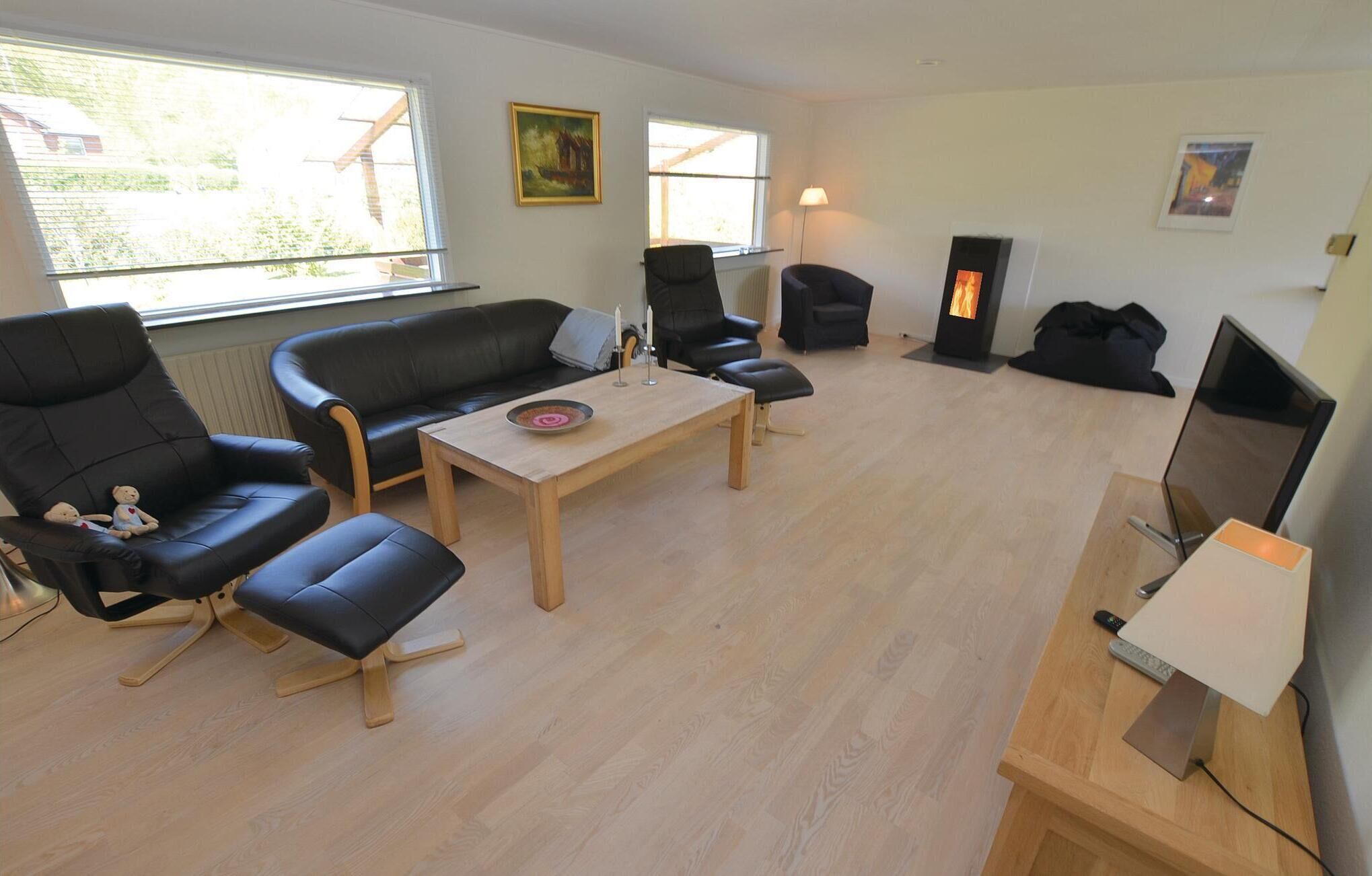 A living room with a sofa, chairs, a coffee table, a fireplace, and a TV.
