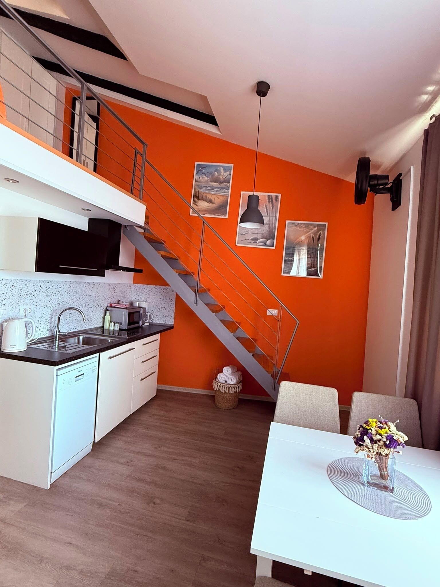 Un appartement moderne doté d’une cuisine, d’un coin repas et d’un escalier.