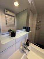 Chuveiro, secador de cabelo, toalhas de banho, papel higiênico