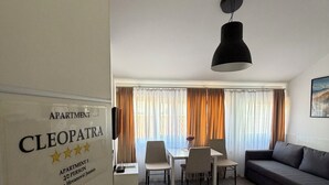 Una sala de estar moderna con comedor, un sofá, una mesa y una araña.
