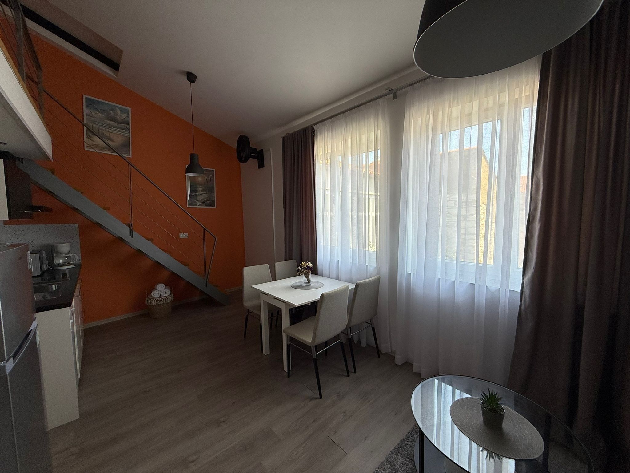 Un espace de vie moderne comprenant un escalier, un coin repas et une cuisine.