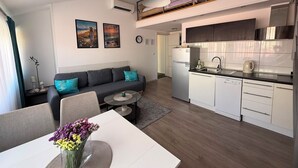 Un apartamento moderno con sala de estar, comedor, cocina y un balcón.