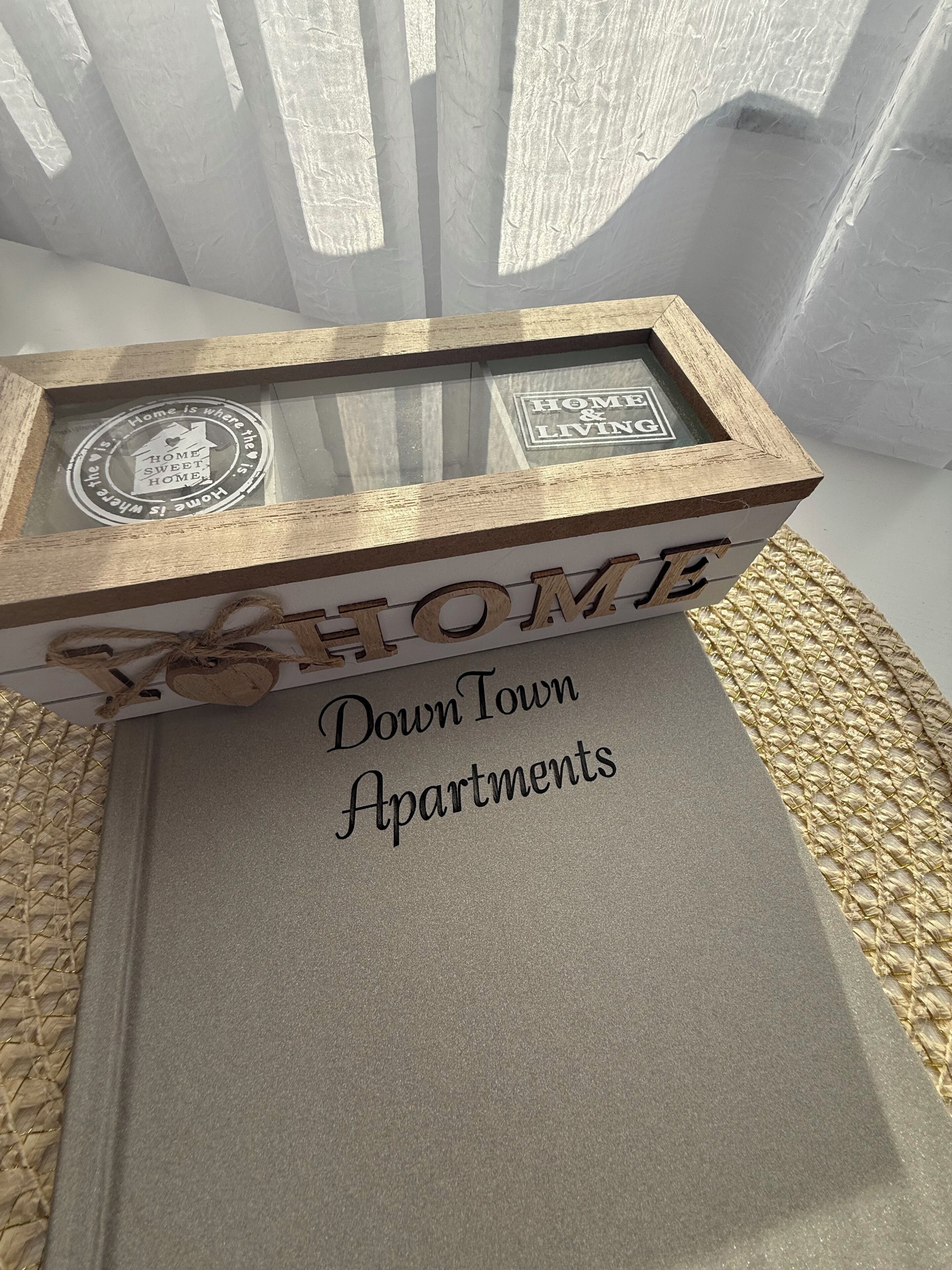 A wooden box with the words "HOME" and "Down Town Apartments" on it.
