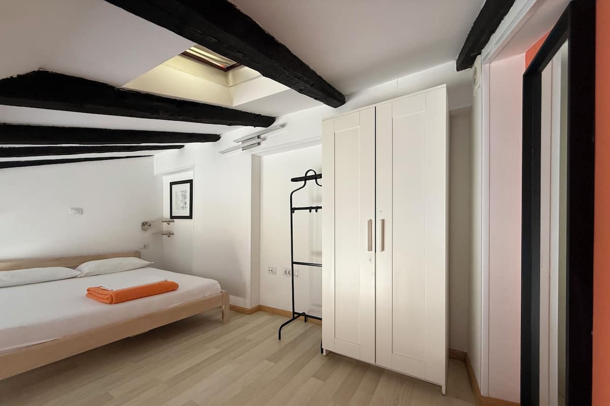 A modern bedroom with a bed, wardrobe, and a walk-in closet.