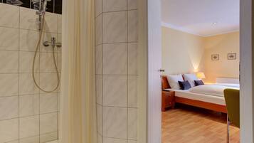 Een moderne badkamer met een douche en apart toilet.