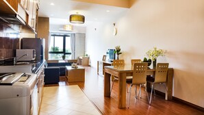 A modern kitchen with a dining area, wooden cabinets, and a dining table with chairs. - Lake House Studio (Hanoi)