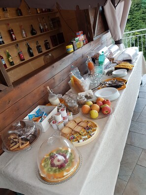 A buffet table with various food items, drinks, and condiments. - Villa Catiè (Gragnano)
