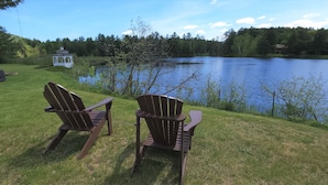 Two Adirondack chairs facing a lake with a gazebo in the background. - Sara Placid Inn & Suites (Saranac Lake)