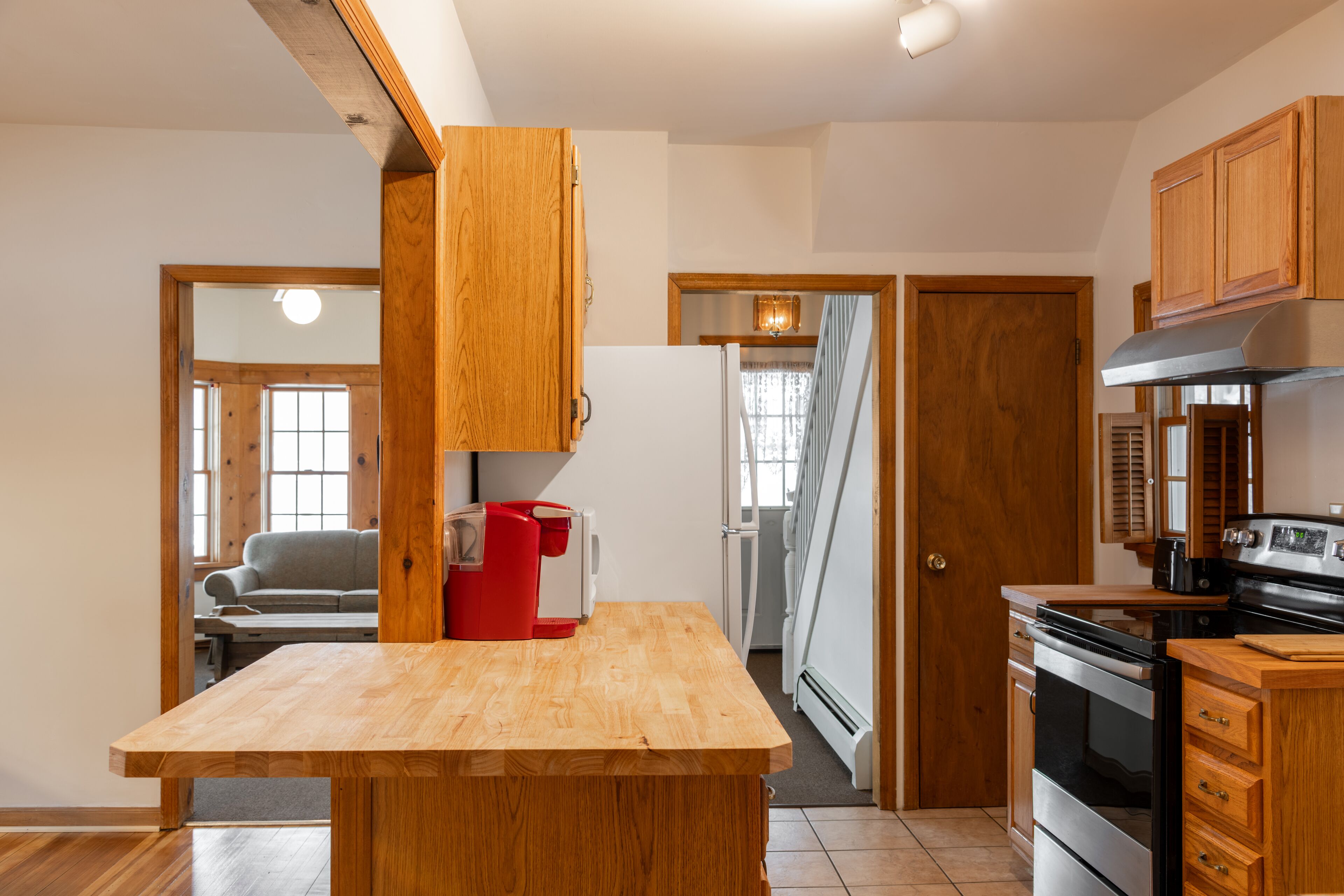 A kitchen with wooden cabinets, a central island, and a stove.