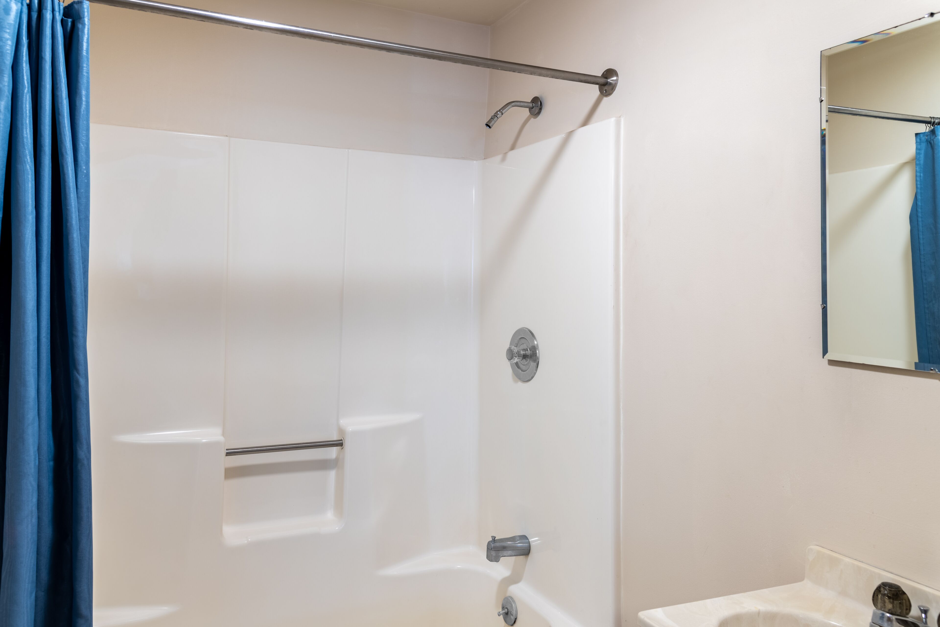 Een badkamer met een douche, toilet en wastafel.
