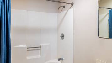 Een badkamer met een douche, toilet en wastafel.