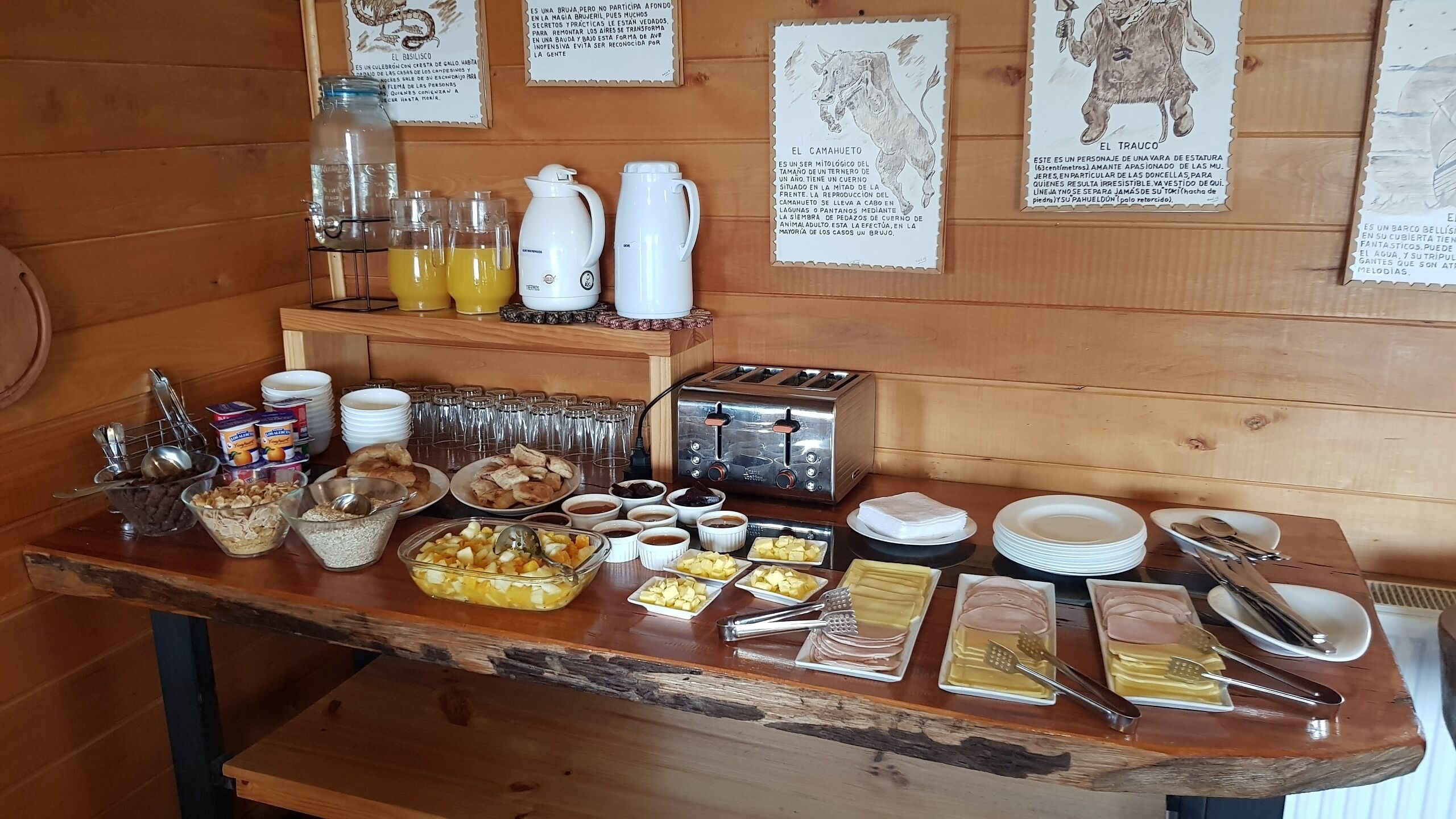 A breakfast buffet with various food items, utensils, and a toaster.