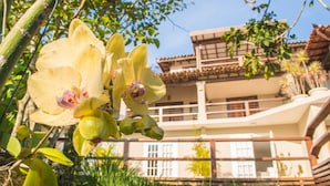 Ein Gebäude mit Balkon und Garten, der Orchideen enthält.