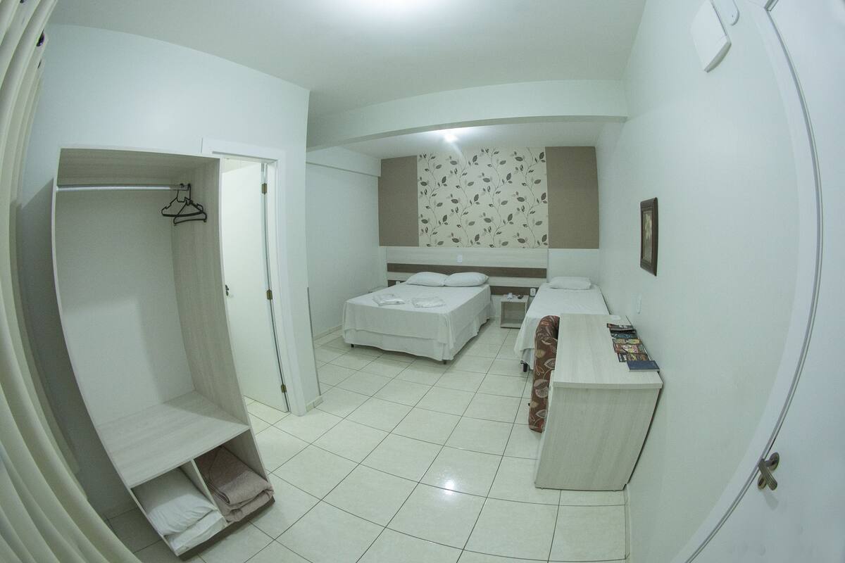 Une chambre comprenant un lit, un bureau, une armoire et un placard.