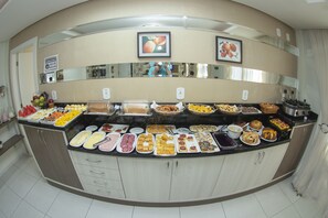 A buffet with various food items and a sign indicating the use of a mask. - Hotel Sambakia (Realeza)