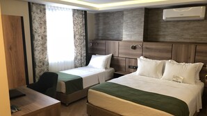 Una habitación de hotel con dos camas, un escritorio y un minibar.