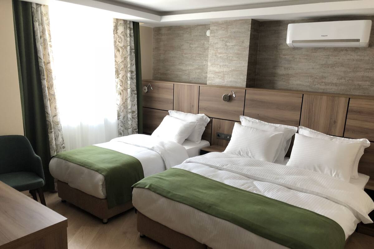 Una habitación de hotel con dos camas, un escritorio y una silla.
