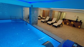 Una piscina con sillones de descanso y una zona de recepción.