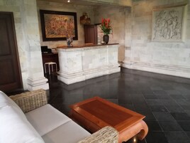A spacious lobby with a central seating area, a reception desk, and a large wall mural.