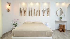 A bedroom with a large bed, a wall-mounted light fixture, and a mirror. - Blue Sky Summer (Naxos)