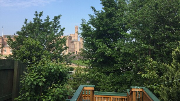 Una vista di un edificio simile a un castello, circondato da una vegetazione rigogliosa.