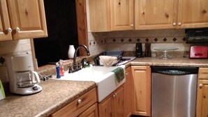 A kitchen with wooden cabinets, granite countertops, a stainless steel dishwasher, and a coffee maker. -  Miles to VIR, Caesar's VA Casino,  Martinsv'l , S.Boston, Priv. Pool seasonal! (Sutherlin)