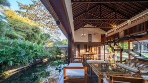 Un espace intérieur moderne comprenant un coin repas, une piscine et un escalier menant à un niveau supérieur.
