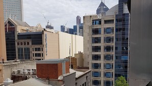 A high-rise building with multiple windows and a flat roof, surrounded by other buildings and a clear sky. - Nice city stay at Collins apartment (Melbourne)
