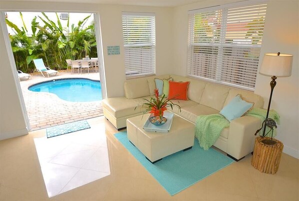 A living room with a pool, a sofa, and a lamp.