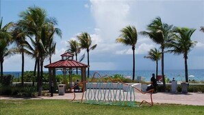 A park with a gazebo, palm trees, and a playground.