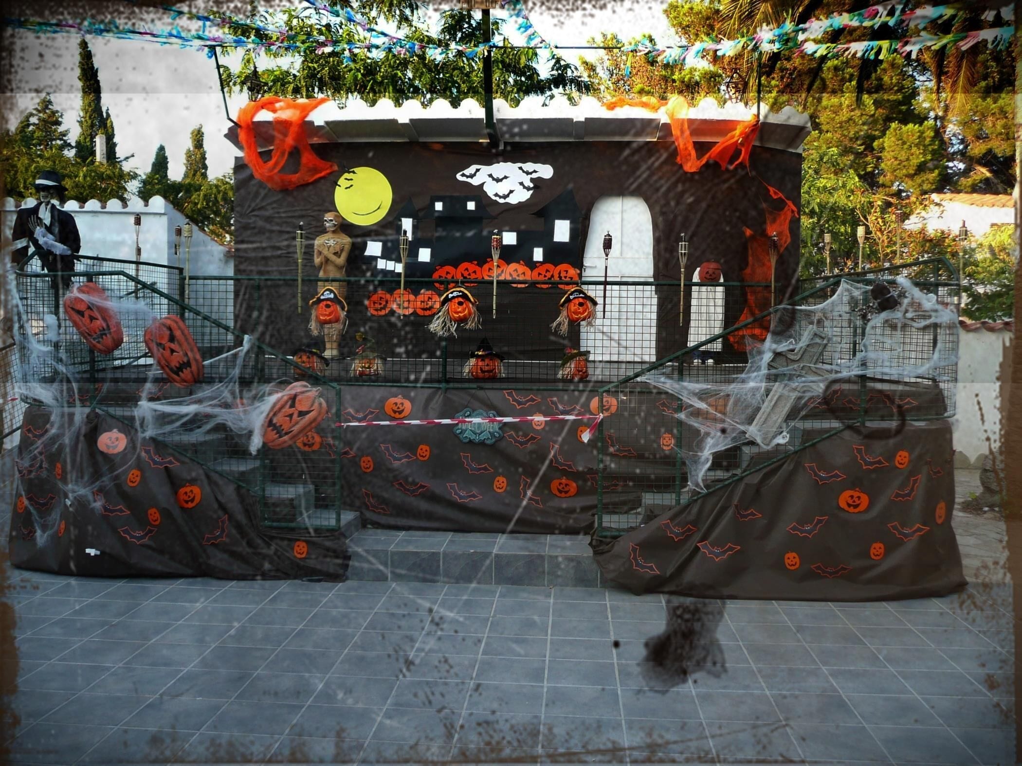 A Halloween-themed setup with a decorated booth, pumpkins, and a spider web.