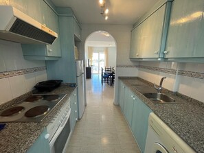 Enjoy cooking in this well-equipped kitchen with a stainless steel sink, double oven, and range hood.