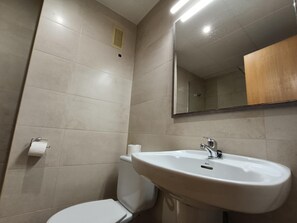 A bathroom with a white sink, toilet, and mirror. - APCOSTAS Lotus / One Bedroom (Blanes)